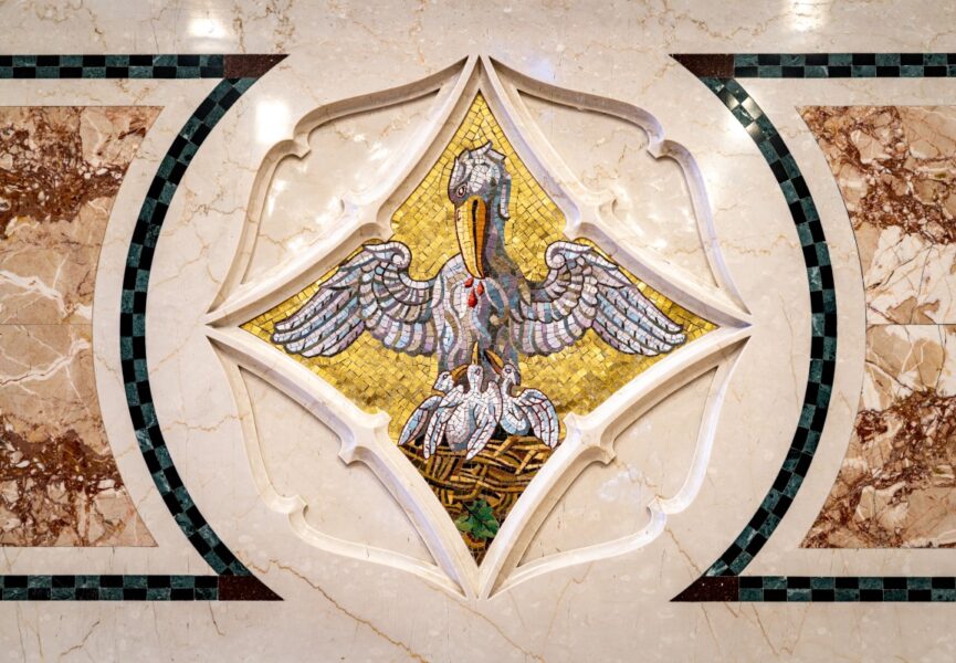 artisan hand-carving Gothic stone leaf motif with chisel and hammer showing craftsmanship and respect for original detailing