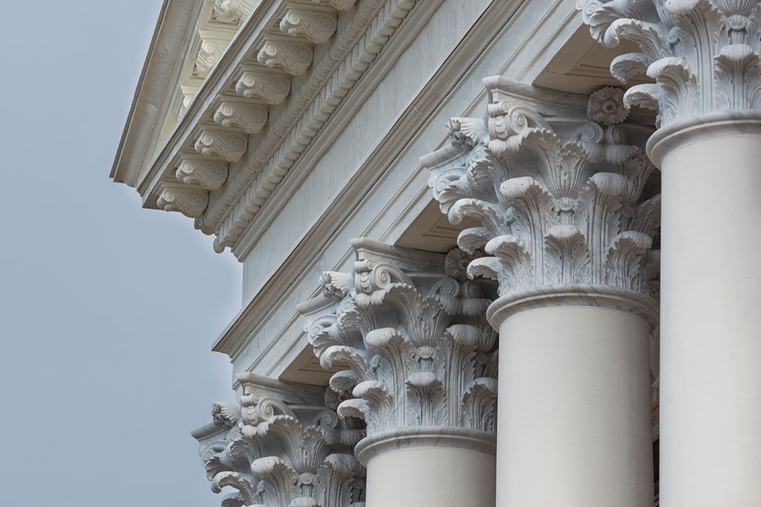 A high-precision Corinthian column capital carved from white marble, showing intricate leaf details and floral motifs for a historic restoration project.